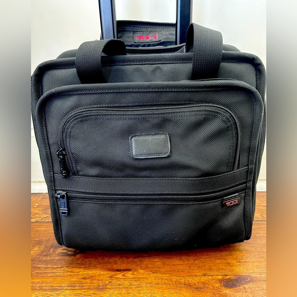 TUMI Black computer bag with wheels and 4 pockets.